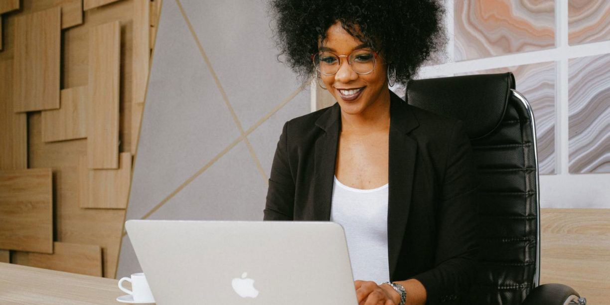 woman with afro typing on laptop