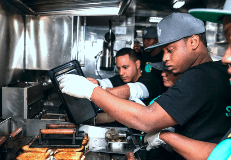 man in black with gray hat making grilled cheese