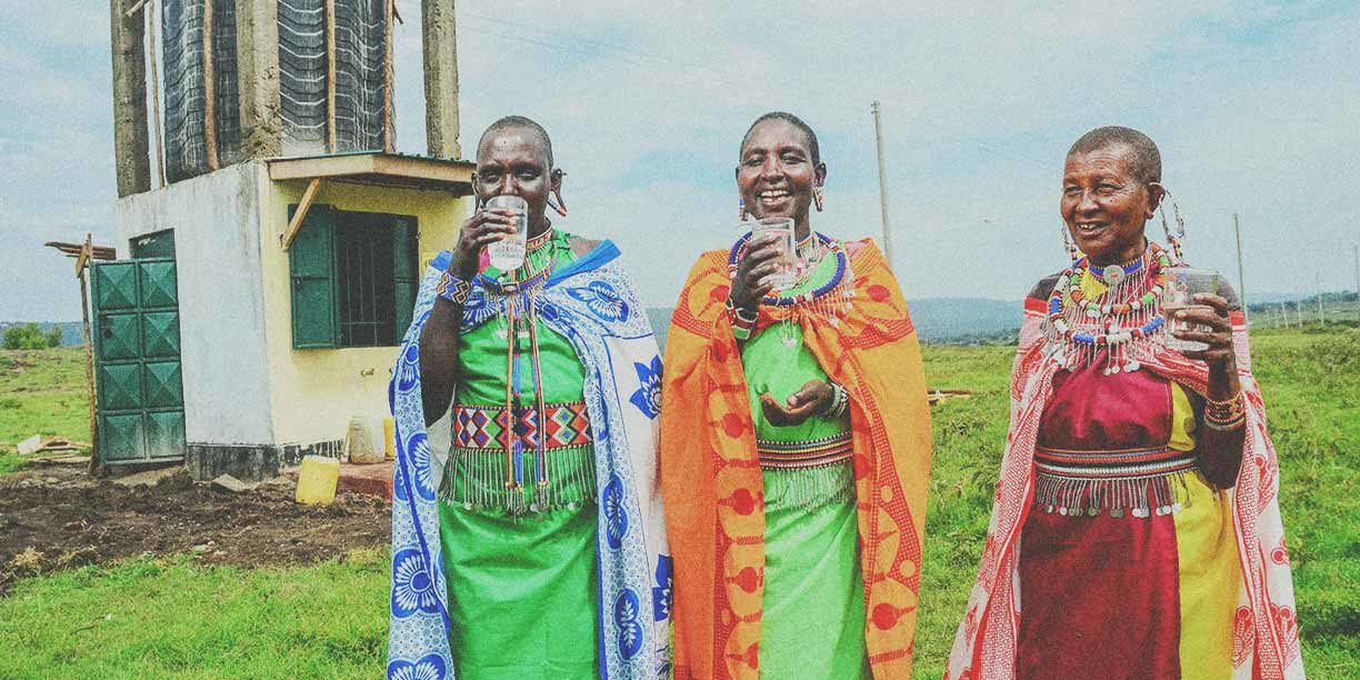 Women in bright clothing drinking clean water