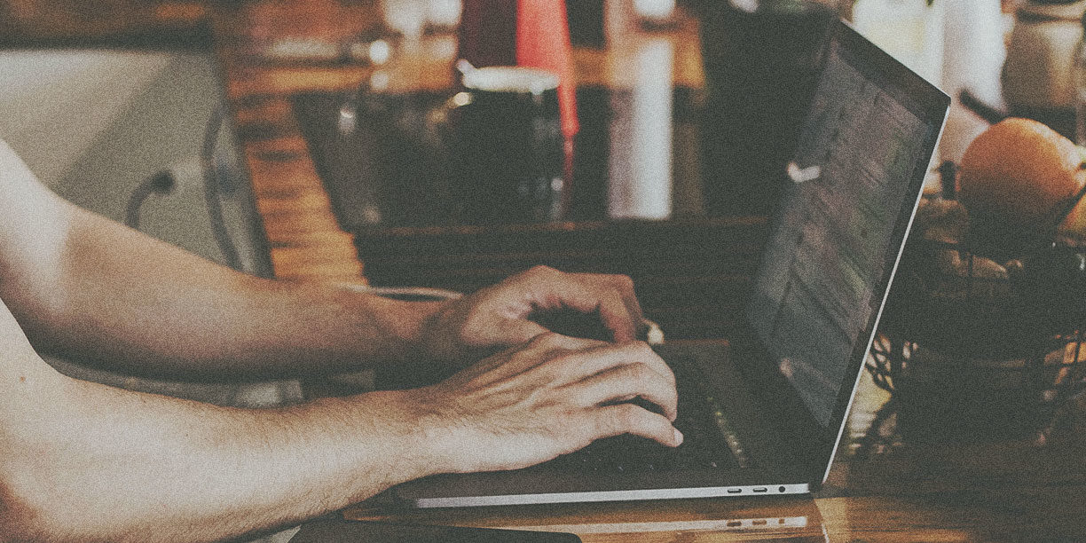 hands typing on a laptop keyboard