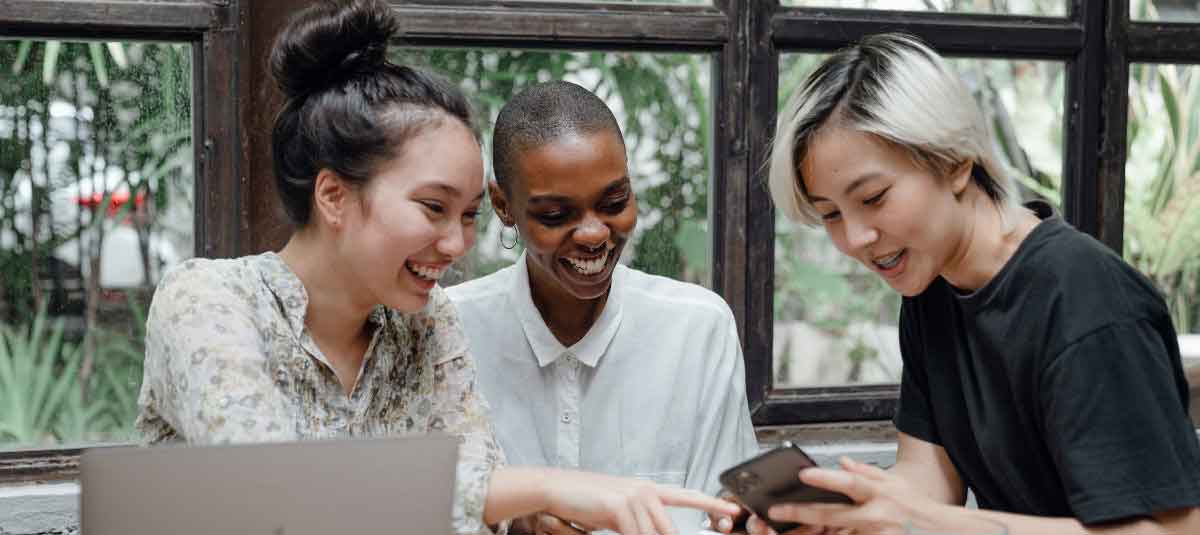 girl showing two women her phone