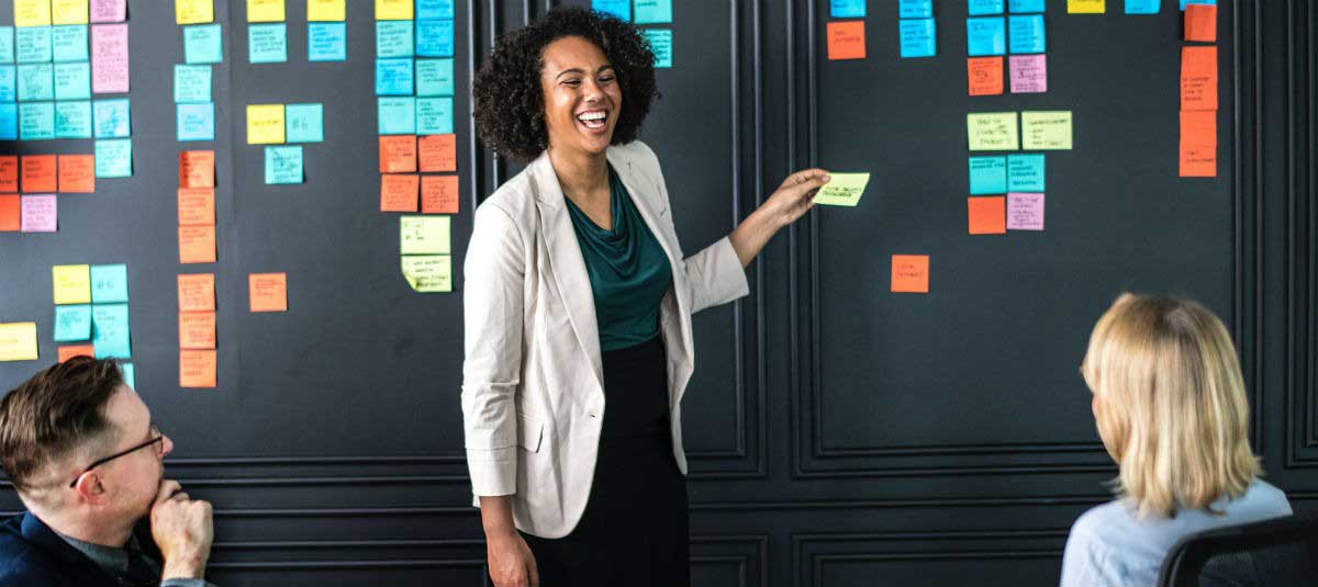 woman putting sticky notes on a wall