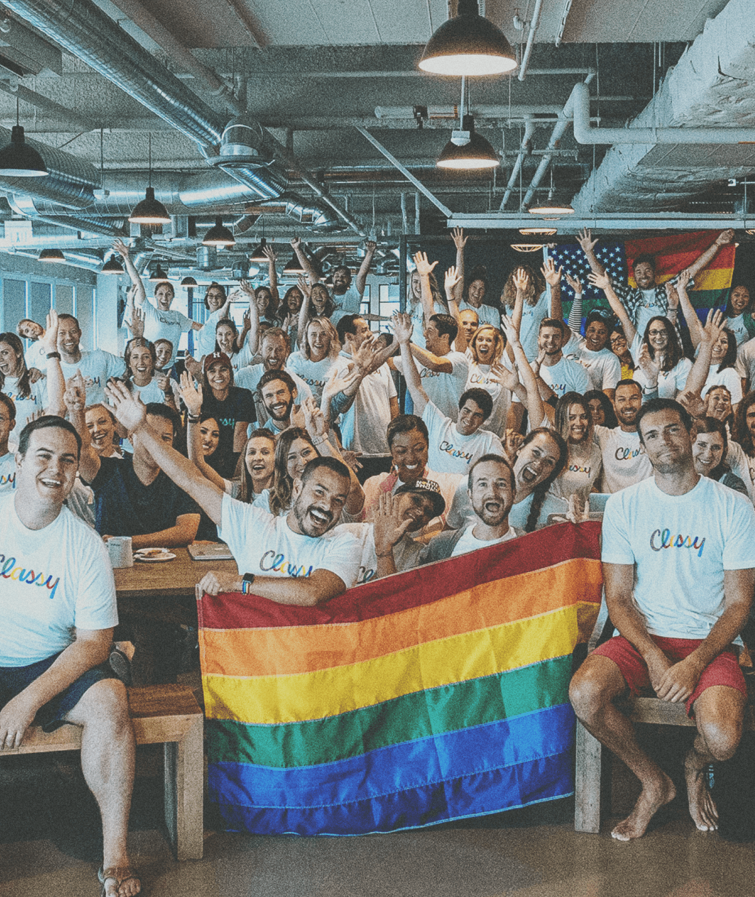 Team photo of Classy employees wearing Classy tshirts holding a rainbow flag