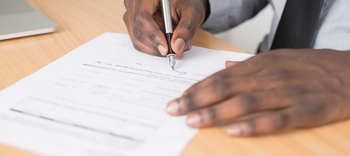 man signing paper