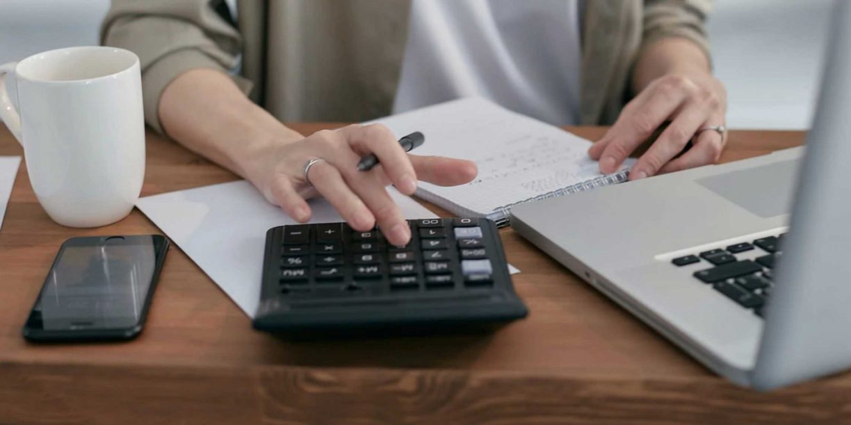 woman typing on a calculator