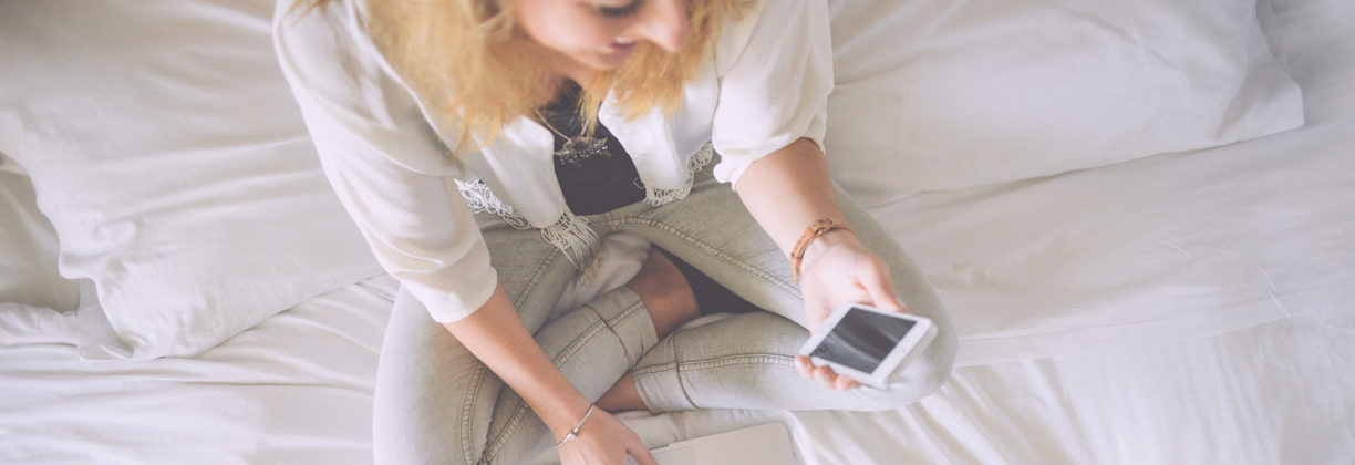 Woman on Phone in Bed