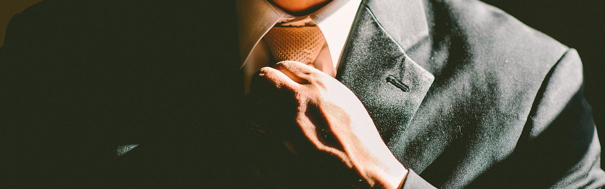 man putting on tie