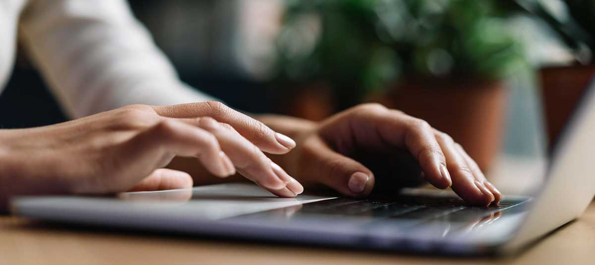 hands typing on a laptop keyboard