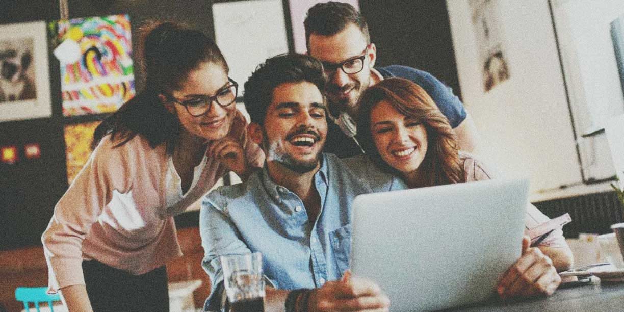 young men and women looking at laptop screen