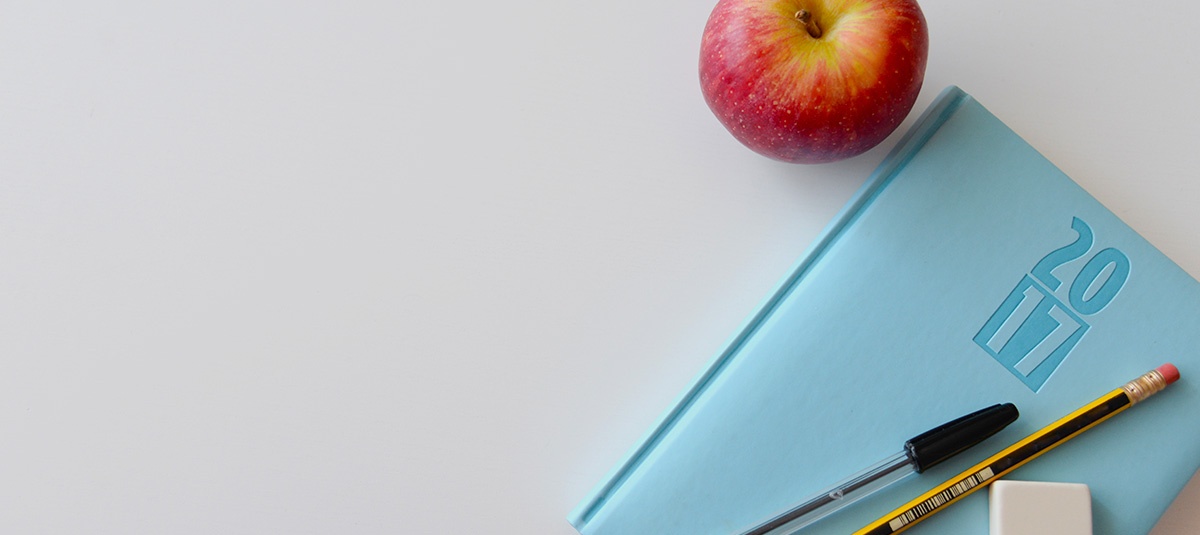apple, notebook, pens desk setup