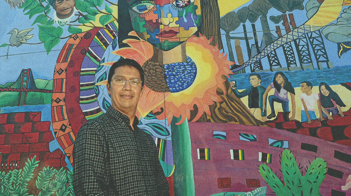 man posing in front of art mural