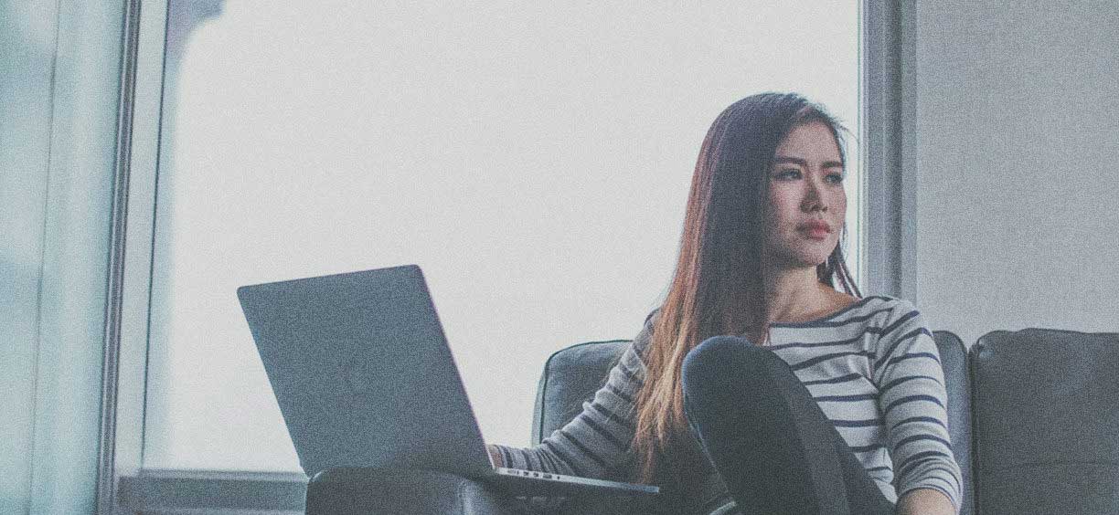 woman on couch with macbook