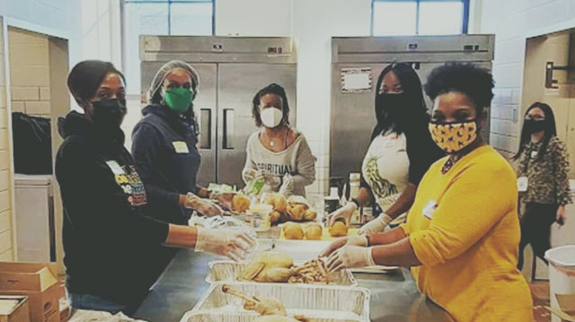 female volunteers cooking meals at soup kitchen