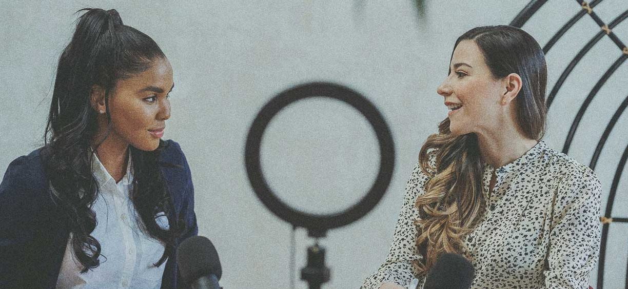 two women filming with a ring light