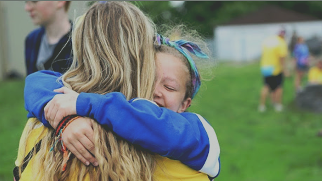 young girl hugging camp counselor