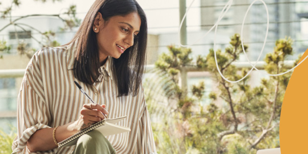 woman taking notes outside in a garden