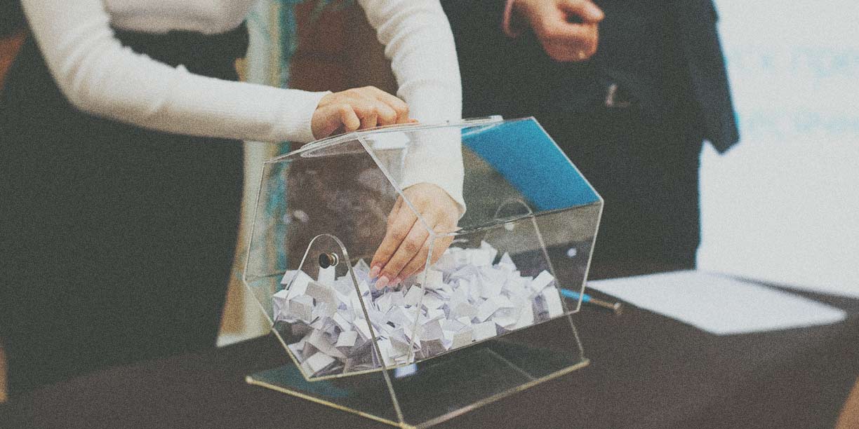 Person reaching into a raffle basket to select the winning ticket