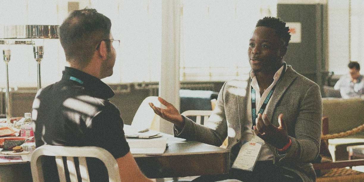 two people sitting at a table having a conversation