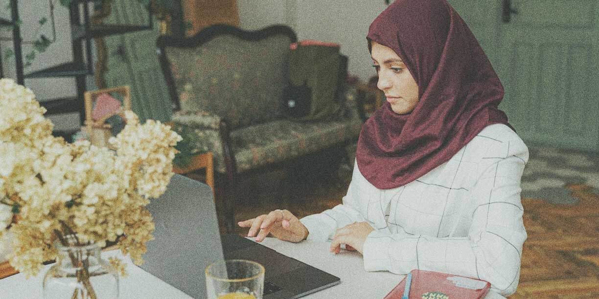 woman in white working on her laptop