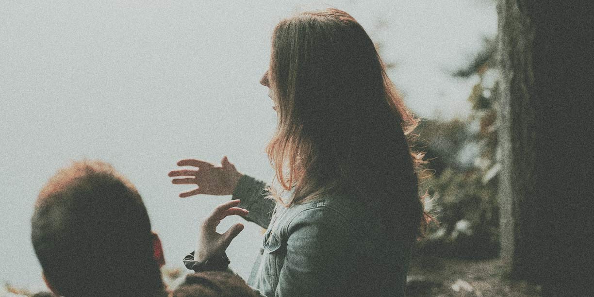 Woman standing outside talking to a man