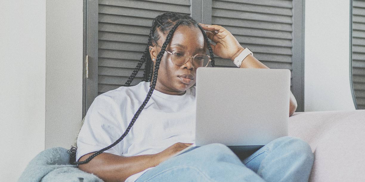 Woman in white t-shirt typing on laptop